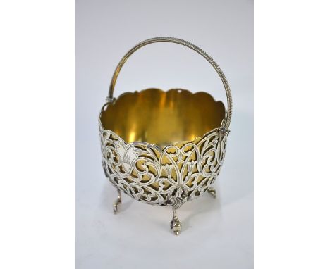 A Victorian pierced bonbon basket with beaded hinged handle and scroll feet, George Unite, Birmingham 1858, fitted with an as
