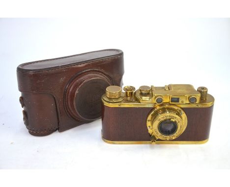 A replica Leica brass and wood camera, in vintage Leica leather case