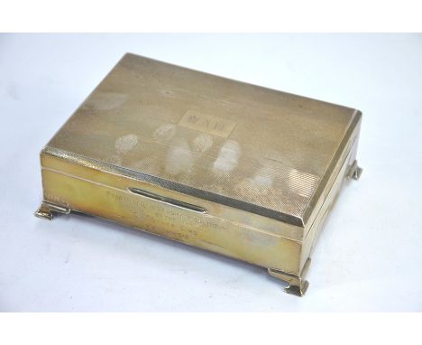 An Art Deco engine-turned silver cigarette box on bracket feet, Lanson Ltd, Birmingham 1935 17 cm wideEngraved presentation i