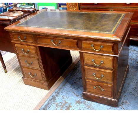 An Edwardian walnut twin pedestal desk, the top with tooled leather surface over an arrangement of nine drawers with original