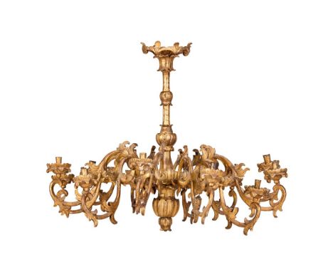 AN ITALIAN CARVED GILTWOOD TWELVE LIGHT CHANDELIER  18TH CENTURY AND LATER  Shaped scrolling stem supporting single tier of 1
