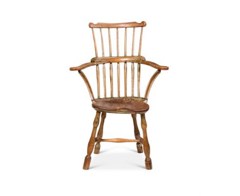 AN ASH AND ELM WINDSOR ARMCHAIR  19TH CENTURY With a yoke toprail and comb back, scrolled arms and a shaped saddle seat on tu