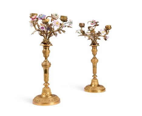 A PAIR OF GILT BRONZE CANDLESTICKS  FRENCH, 19TH CENTURY  With engine turned banded decoration and later fitted with porcelai