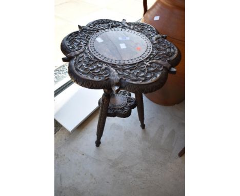 A 19th Century occasional table, heavily carved animalistic and foliate decoration, on tripod legs, diameter approx. 39cm