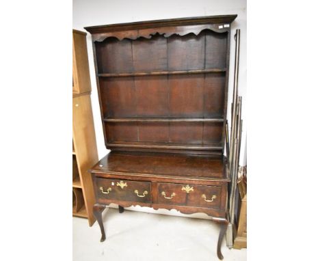 A period oak dresser in the Georgian style, with shaped apron to delft rack over two drawer base on cabriole legs, compact si