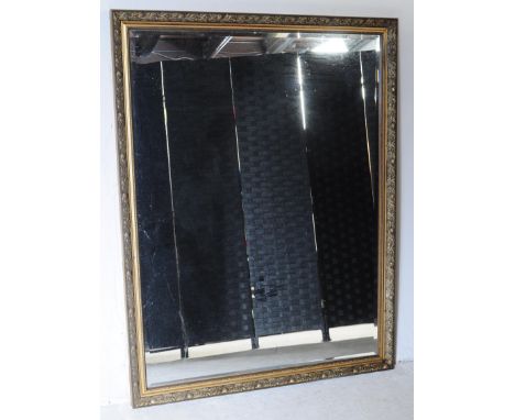 A vintage 20th century gesso gilt hanging over mantel wall mirror. Having repeating foliate pattern to frame on outer with be