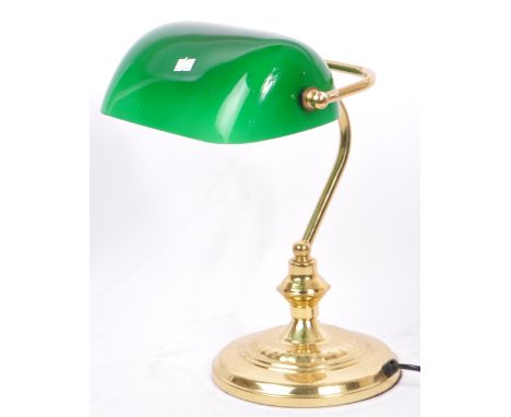 A 20th century 1920s style brass and glass bankers lamp. The lamp having a green cased glass shade over hooked brass shaft up