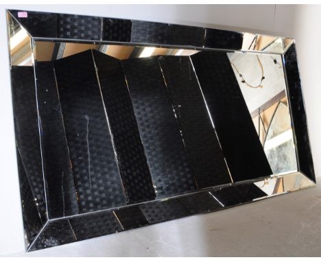 A large contemporary designer wall hanging mirror having large bevel edge to glass. Central mirrored panel, framed. Made in B