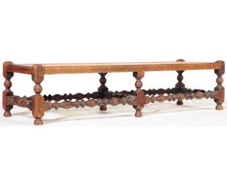 A 19th century Victorian carved oak Jacobean revival cane foot stool. The stool having square block legs united by bobbin tur