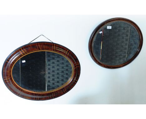 An early 20th century faux rosewood oval hall mirror. Cushion shaped frame with central oval plate mirror glass together with