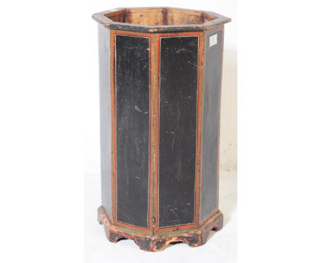 An early 20th century hand painted wooden stick stand of hexagonal form painted in black with red and gilt border to each pan