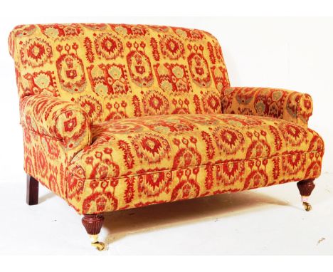 A contemporary scroll arm two seater sofa by Multiyork. Upholstered in a series of abstract floral motifs in red, blue, purpl