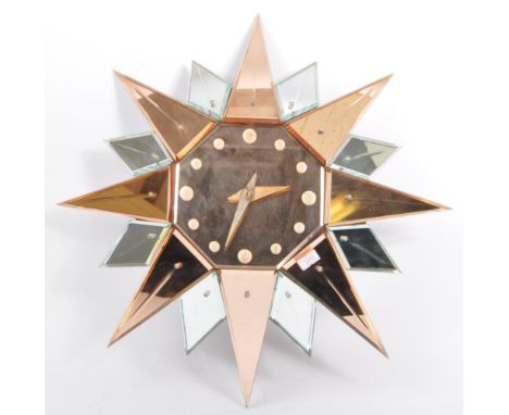 An original Art Deco starburst mirrored glass wall clock. Mirrored glass being of clear &amp; peach glass colourway. With rep