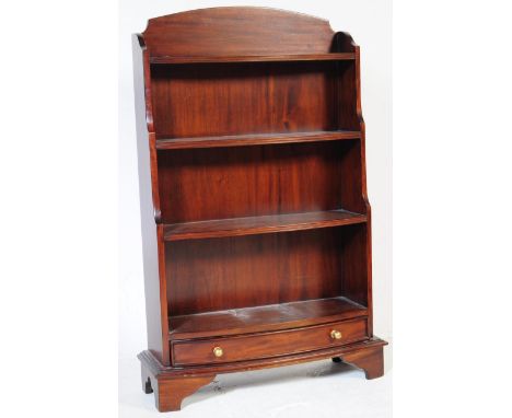 A 20th century Reproduction mahogany waterfall bookcase cabinet. Raised on bracket feet with drawer under open shelves above.