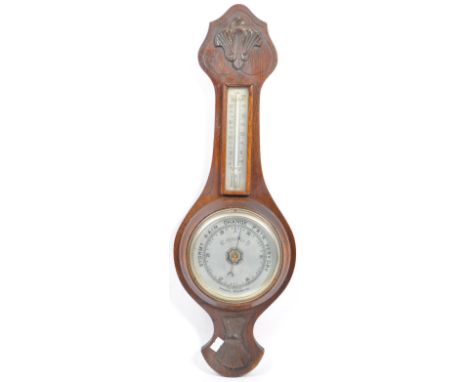 Early 20th century oak cased wall hanging aneroid barometer. Having carved top into a tapering neck with temperature gauge. C