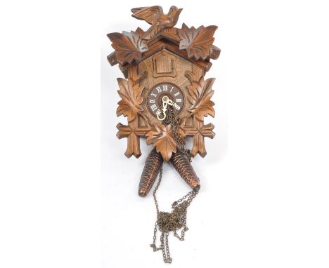 Lotscher - A Swiss carved hanging wall cuckoo clock. Having carved foliate wood decoration to front. With acorn weights and c