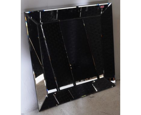 A small contemporary designer wall hanging mirror having large bevel edge to glass. Central mirrored panel, framed. Made in B