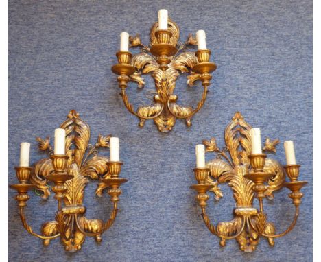 A set of three gilt-metal mounted three-light wall appliques in the Classical style, the backs as fleur de lys; each approx. 