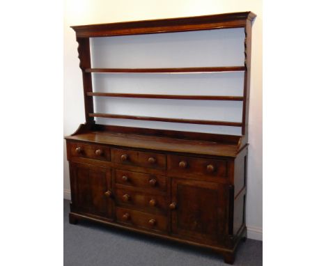 A late 18th century George III period oak dresser; the shelved superstructure above an arrangement of six drawers in a 'T' fo
