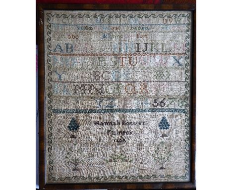 An early-18th century framed and glazed George III period sampler detailing letters, numerals, stylised trees etc. by Hannah 