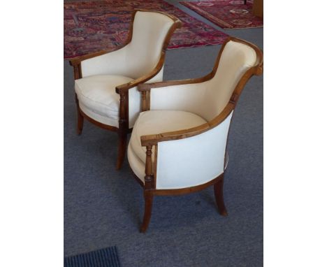 A pair of Louis XVI upholstered and walnut show-wood fauteuill, the arms upon turned supports, bowed front-rail and sabre fro