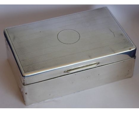 An early 20th century cedar wood lined silver cigarette box; engine-turned decoration to the lid and circular central vacant 