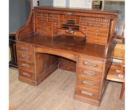 A large twin pedestal oak roll top desk with fitted interior, the lock inscribed 'The Arvon', width 153cm, depth 89cm & heigh