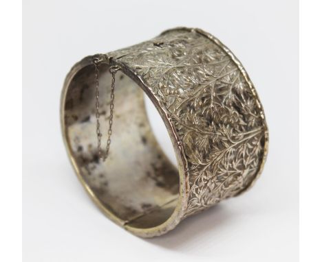 A Chinese silver bangle, the exterior decorated with bees amongst bamboo, indistinct two character mark to interior, diam. 6c