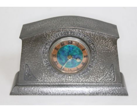 An Arts & Crafts pewter mantel clock by Tudric for Liberty & Co, number 01156, domed top, hammered finish, enamel dial with c