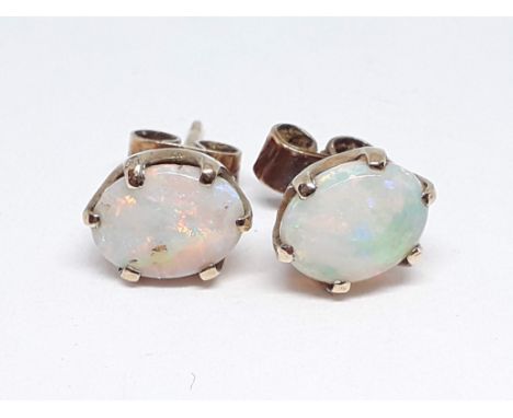 A pair of hallmarked 9ct gold precious opal stud earrings, each cabochon measuring approx. 8mm x 6mm x 2mm, gross wt. 1.59g. 