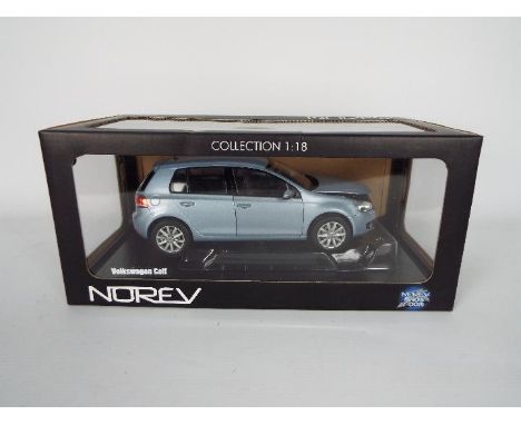 Norev - A boxed Norev 'Show Room' Collection 1:18 scale #188450 Volkswagen Golf. The model in Metallic Blue appears to be in 