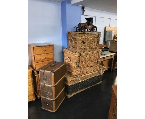 A travel trunk, three large wicker baskets and a model car