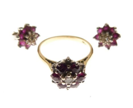 Yellow metal, diamond and ruby cluster ring of flowerhead design with central diamond and six rubies, shank stamped 18ct, 3.7