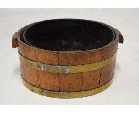 Brass and oak cooper made tub having metal liner, together with a pair of butter pats and a wooden ladle, 40.5cm diameter  