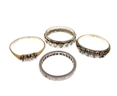 Four assorted rings to include; a yellow metal eternity ring stamped 9ct, unmarked eternity ring size J, and two others, 9.7g