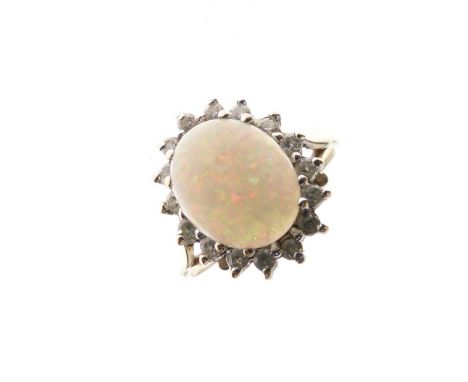 9ct gold and opal dress ring, the oval stone approximately 10mm x 8mm, within a border of sixteen small stones, size M, 2.5g 