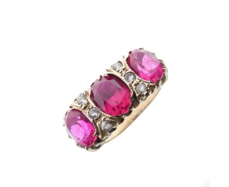 Unmarked yellow metal dress ring set three large oval faceted ruby-coloured stones (synthetic corundum) with two sets of thre