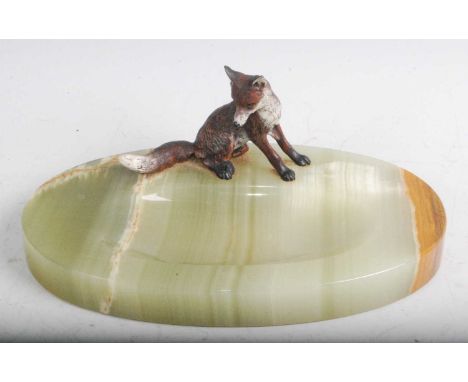An early 20th century onyx table centrepiece of oval form, surmounted by a cold painted model of a fox, w.19cm.