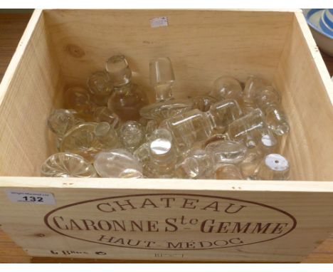 A box containing a large assortment of various clear glass decanter stoppers 