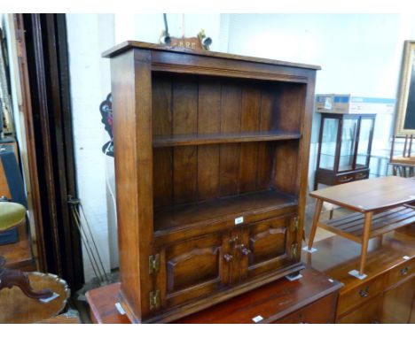 A reproduction solid oak dwarf open fronted bookcase, having single fixed shelf above two base cupboard doors.
