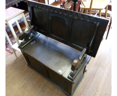 A mid Century Priory style dark oak monks bench, with hinged seat enclosing storage cupboard.