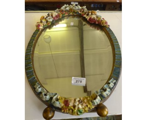 An early 20th Century oval bevelled barbola type mirror, with floral decoration and easel back, 58x34cm 