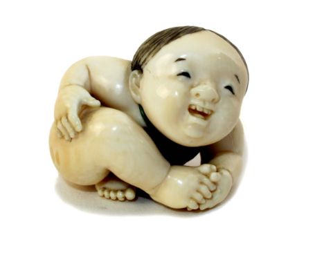 Japanese Meiji period (1868-1912) carved and stained ivory netsuke, by Yasuaki (Homei), of a crawling infant wearing a red bi