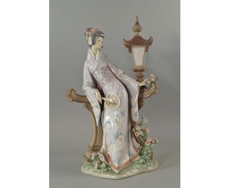 A Lladro figure of a Japanese lady, 20th century, modelled leaning against an Oriental themed lamp post, with a fan in her ha