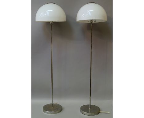 A pair of chrome and domed plastic standard lamps, designed by Tchaik Chassay, 126cm high, together with a wrought iron lamp 