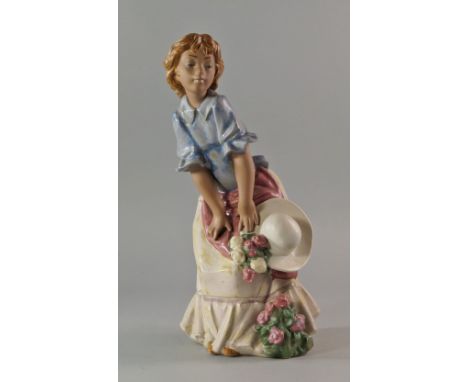 A Lladro porcelain figure of a girl, 20th century, modelled with a blue shirt, yellow dress and hat, with sprays of flowers t
