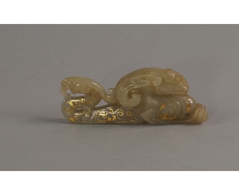 A Chinese jade carving of a mythical beast, in the archaic style, with damascened decoration, 10cm long
