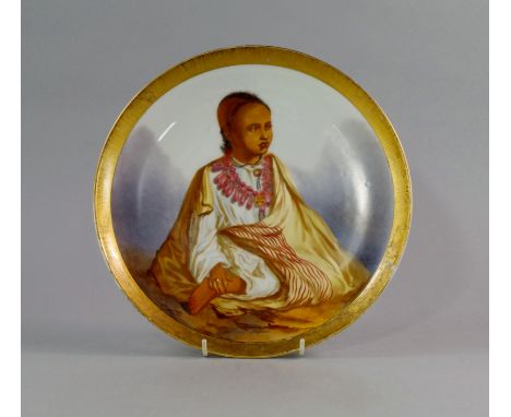 An English porcelain plate, 19th century, painted to the centre with an Orientalist scene of a seated Arab child, in a white 