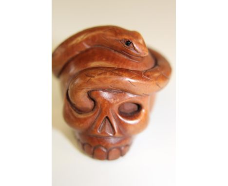 A box wood netsuke in the form of a skull &amp; snake