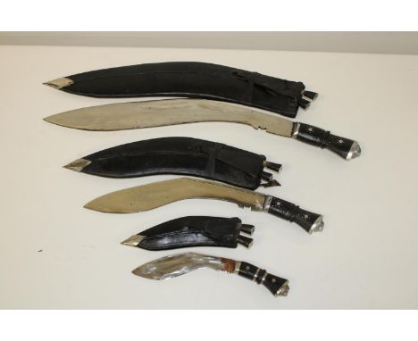 A set of three vintage Kukri knives in leather scabbards, with lions head motive &amp; associated small daggers 